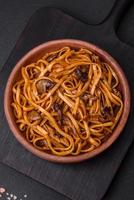 delicioso tallarines o udon con hongos, sal, especias y hierbas foto