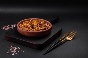 delicioso tallarines o udon con hongos, sal, especias y hierbas foto