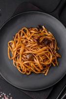 delicioso tallarines o udon con hongos, sal, especias y hierbas foto