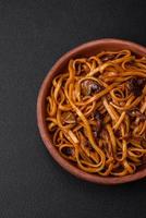 delicioso tallarines o udon con hongos, sal, especias y hierbas foto
