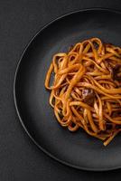 delicioso tallarines o udon con hongos, sal, especias y hierbas foto