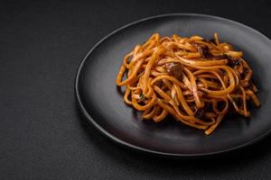 delicioso tallarines o udon con hongos, sal, especias y hierbas foto