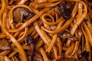 delicioso tallarines o udon con hongos, sal, especias y hierbas foto