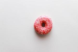 Pink donut on pink background flat lay photo