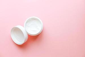 Top view laying out hand cream on pink background photo