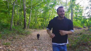 The dog walks outdoors. He walks in the forest with the dog owner. video