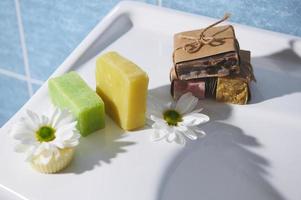 Still life with various eco soap and solid shampoo with natural ingredients on a white ceramic surface in the bathroom photo