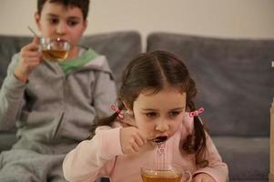 adorable niños- chico y chica, Bebiendo herbario té mientras descansando después edificio de madera estructuras desde de madera ladrillos y bloques a hogar. multa motor habilidades desarrollo, educativo tablero juegos concepto foto