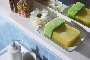 Selective focus on white chamomile flower, organic soap bars, dry solid shampoos, spa scrubs in the home bathroom photo