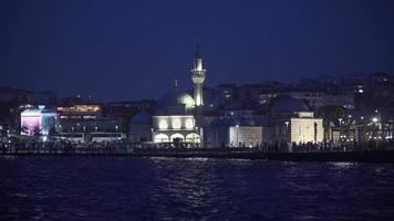 noite mesquita e cidade. Visão do mesquita e multidão a partir de a mar às noite. video