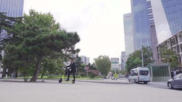 Handsome Caucasian Businessman Riding Electric Scooter Near Modern Building. Handsome caucasian businessman driving electric scooter near modern building. Going to work in the city centre. video