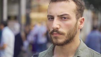 jong Mens op zoek Bij camera in de stad centrum. jong Mens op zoek ernstig Bij camera in modern stad centrum straat. video