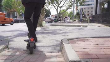 équitation un électrique scooter en plein air. homme d'affaire pieds en utilisant électrique scooter. video