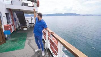 Young man dancing on the ship. In slow motion. Young man on sea voyage is happy and dancing. video