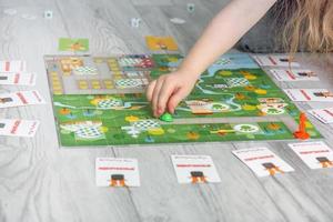 Grodno, Belarus - March 26, 2023 child's hand moves a chip on the playing field in a board game photo