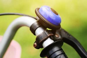 Old rusly and vintage metal blue bell on the handlebar of an old Bicycle in the park photo