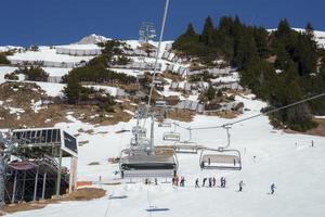 esquí ascensores con turistas en nieve cubierto montaña foto