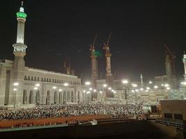 la meca, saudi arabia, abril 2023 - un hermosa ver de peregrinos, alto edificios y luces a noche en el exterior la carretera en masjid al haram, la meca. foto