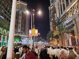 Mecca, Saudi Arabia, April 2023 - A beautiful view of pilgrims, tall buildings and lights at night on the outer road in Masjid al-Haram, Mecca. photo
