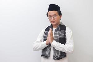 retrato de joven asiático musulmán hombre demostración pedir disculpas y Bienvenido mano gesto. aislado imagen en blanco antecedentes foto