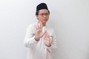 Portrait of young Asian muslim man forming a hand gesture to avoid something or bad things. Isolated image on white background photo