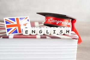 Inglés libro con graduado sombrero, aprendizaje y tutorial para extranjero. foto