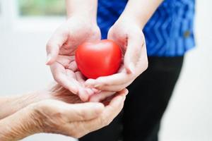 Asian young boy holding old grandmother woman hand together with love and care. photo