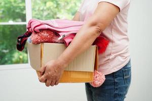 Clothes donations in cardboard box for volunteer. photo