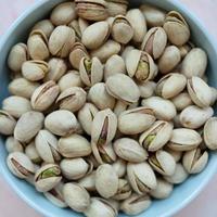 Pistachio in shell in bowl on pink background photo