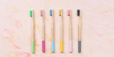 Natural wooden bamboo toothbrushes on pink photo