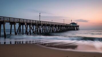 A beach scene with a pier stretching out into the water. photo