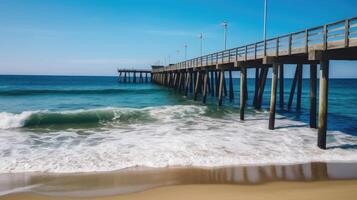 A beach scene with a pier stretching out into the water. photo
