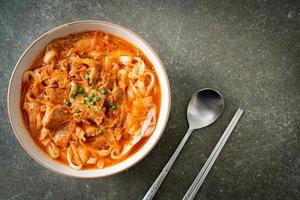 Korean udon ramen noodles with pork in kimchi soup photo