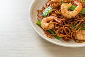 stir-fried yakisoba noodles with green peas and shrimps photo