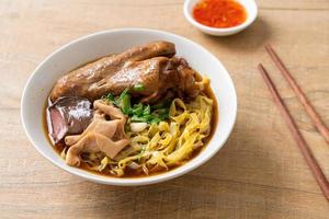 fideos de huevo con pato guisado y estofado en sopa marrón foto