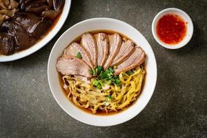 egg noodles with stewed duck in brown soup photo