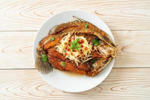 Fried Sea Bass Fish with Fish Sauce and Spicy Salad photo