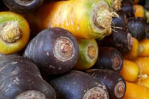 Stack of yellow and black carrots photo