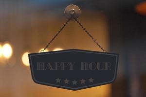 Happy hour sign in the window of a shop photo