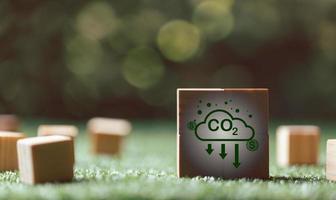 Companies are targeting net zero greenhouse gas emissions. Carbon credit concept.Tradable certificate to drive industry in direction of low emissions in efficiency cost.Wooden cubes with decrease CO2 photo