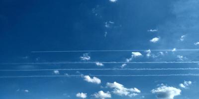 Trace from the plane in the air. Four planes traces. Sky clouds. Abstract blurred blue gradient of the spring sky. photo