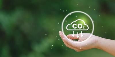 Businessman holding Co2 icon on virtual screen Reduce CO2 emissions to limit global warming. Lower CO2 levels with sustainable photo