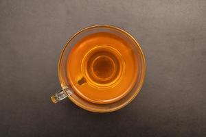 vaso taza de caliente jengibre té en el negro escritorio. foto