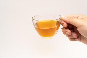 Glass cup of hot ginger tea isolated on white background. photo