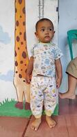 Little cute child boy in the children's playroom measures her height photo