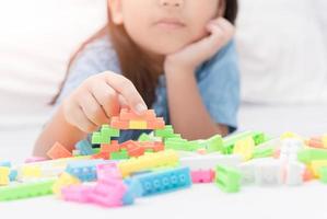 girl play block bricks on bed, education photo
