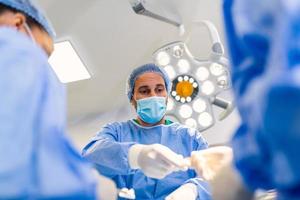 Shot in the Operating Room, Assistant Hands out Instruments to Surgeons During Operation. Surgeons Perform Operation. Professional Medical Doctors Performing Surgery. photo