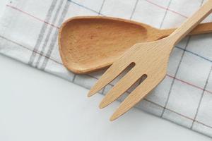 cubiertos de madera, tenedor y cuchara en una tabla de cortar en la mesa foto