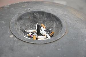 Close up burning cigarette in ashtray on table photo