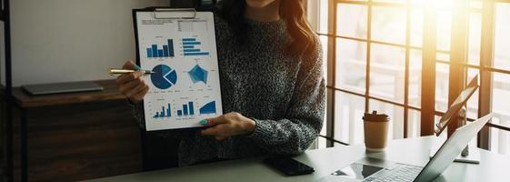 Financial analysts analyze business financial reports on a digital tablet planning investment project during a discussion at a meeting of corporate showing the results of their successful teamwork. photo